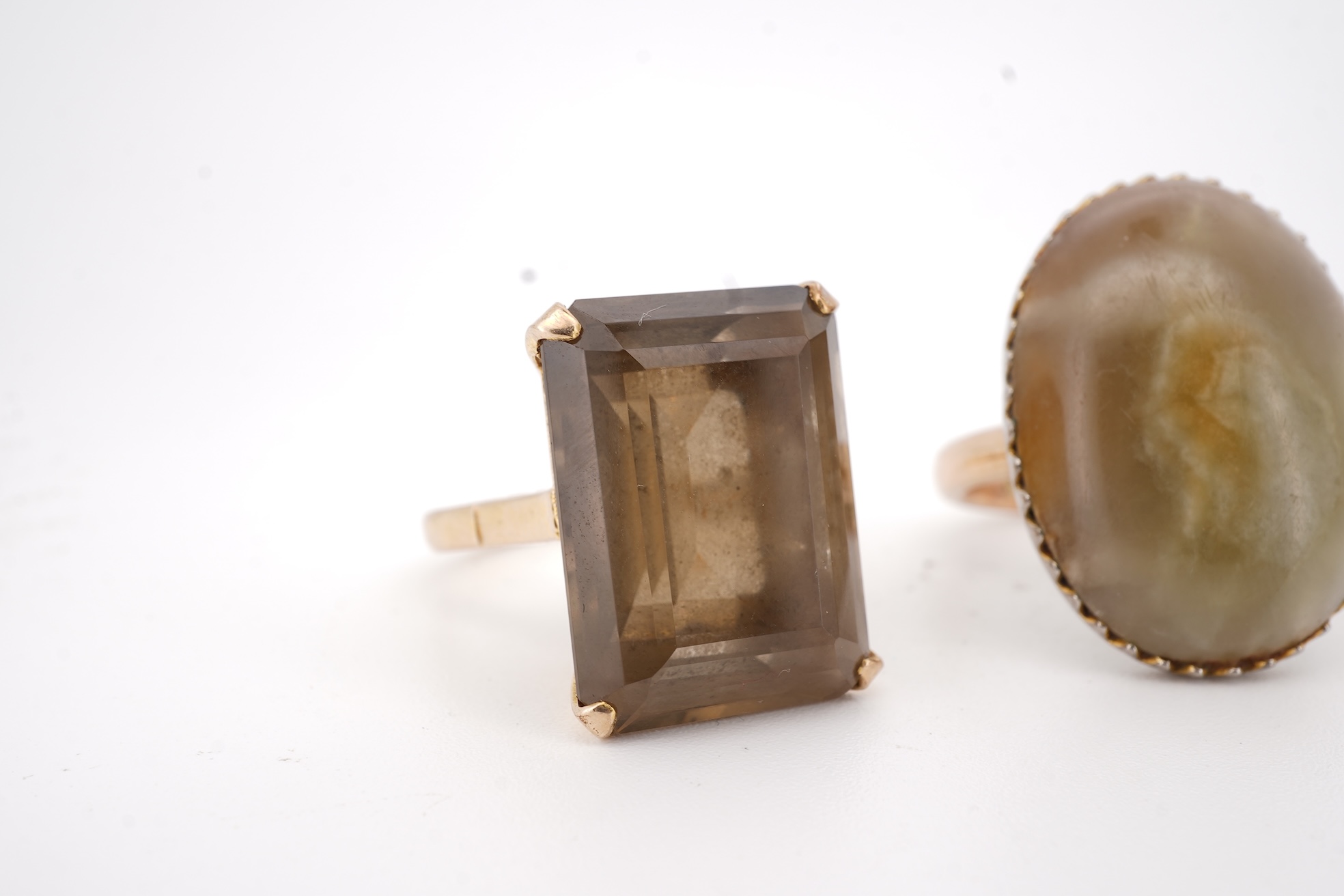 A modern 9ct gold and single stone emerald cut smoky quartz set ring, size N and one other 1960's 9ct gold shank, with a later added agate set white metal mount.